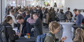 Menschen stehen zusammen und unterhalten sich am Buffet.