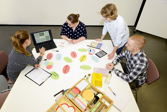 Group work Students sit at a table and work together on a project.
